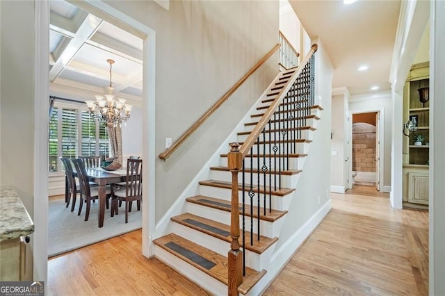 stairs featuring crown molding, beam ceiling, wood finished floors, baseboards, and an inviting chandelier