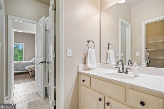 bathroom with ensuite bathroom, tile patterned flooring, and vanity