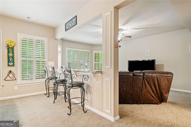 bar with carpet floors, a ceiling fan, baseboards, and visible vents