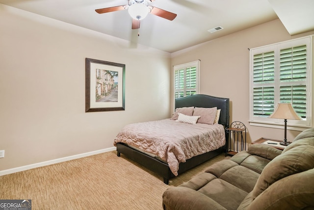 carpeted bedroom featuring visible vents, baseboards, and ceiling fan