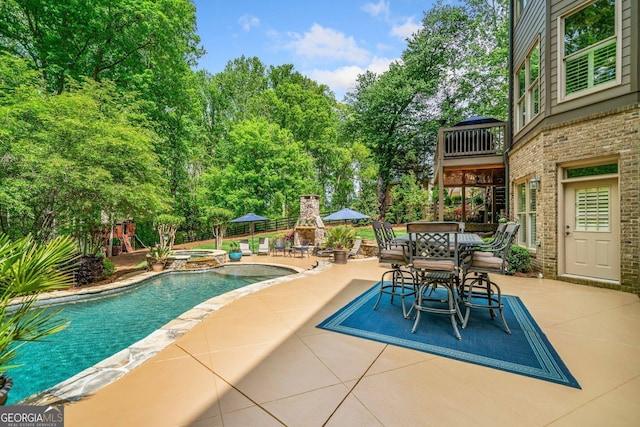 view of pool featuring outdoor dining space, a pool with connected hot tub, and a patio area