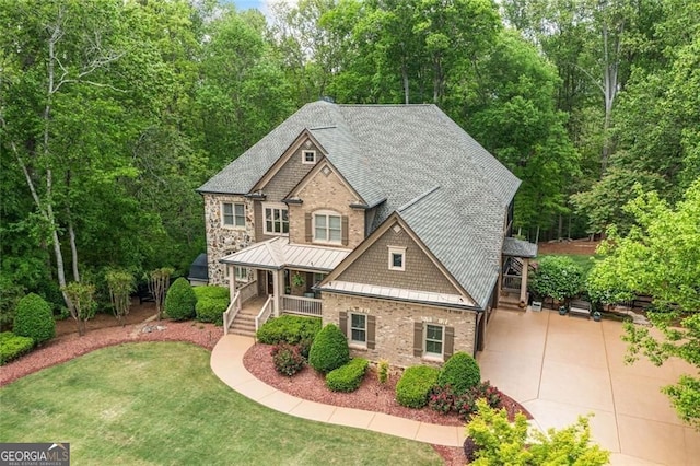 craftsman inspired home featuring covered porch, a standing seam roof, a front lawn, a shingled roof, and stairs