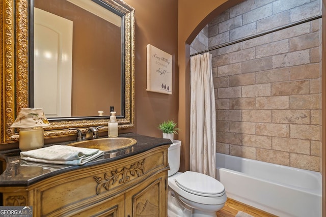 full bathroom featuring vanity, shower / bath combo with shower curtain, and toilet