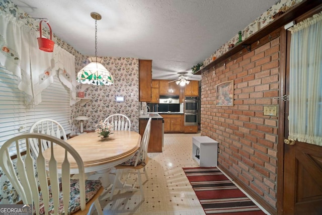 110 Otelia Ln, Covington, GA 30014 - dining space featuring light floors, a ceiling fan, a textured ceiling, and brick wall