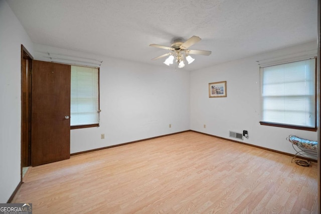 110 Otelia Ln, Covington, GA 30014 - unfurnished room with a textured ceiling, visible vents, baseboards, light wood-type flooring, and a ceiling fan
