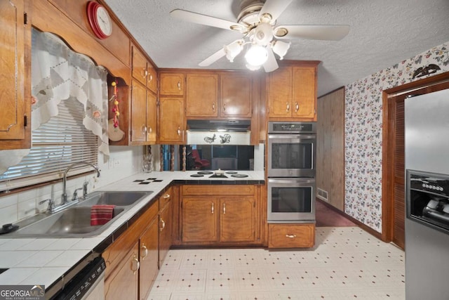 110 Otelia Ln, Covington, GA 30014 - kitchen featuring a textured ceiling, a sink, tile counters, stainless steel appliances, and wallpapered walls