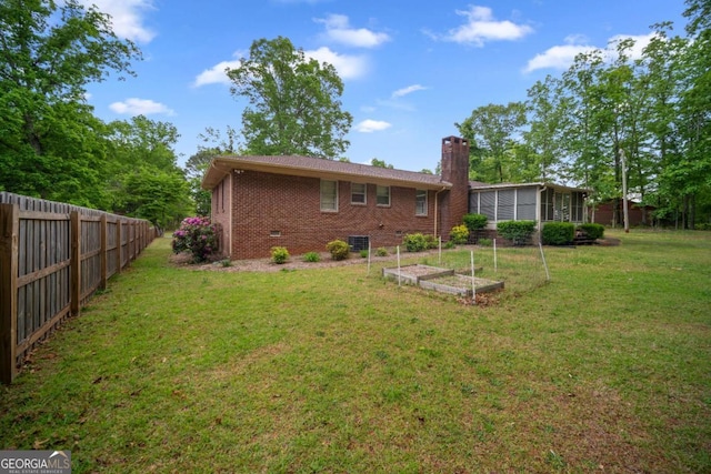 110 Otelia Ln, Covington, GA 30014 - back of house featuring a yard, a chimney, brick siding, a vegetable garden, and fence