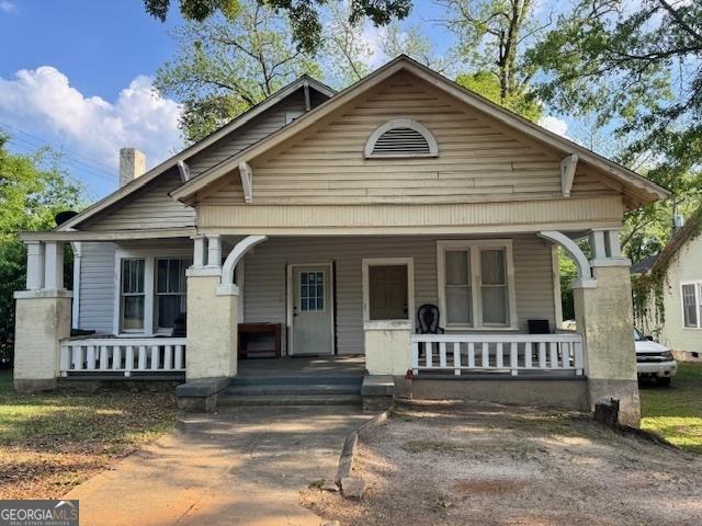 view of front of house with covered porch and a chimney