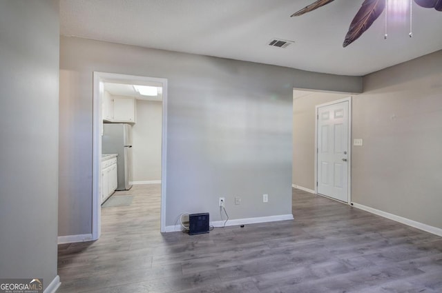 unfurnished room featuring visible vents, ceiling fan, wood finished floors, and baseboards