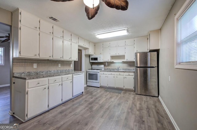 kitchen with a ceiling fan, visible vents, decorative backsplash, and white appliances