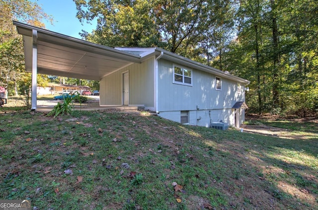 view of property exterior featuring a lawn, central AC unit, and an attached carport