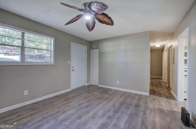 interior space featuring baseboards, wood finished floors, and a ceiling fan