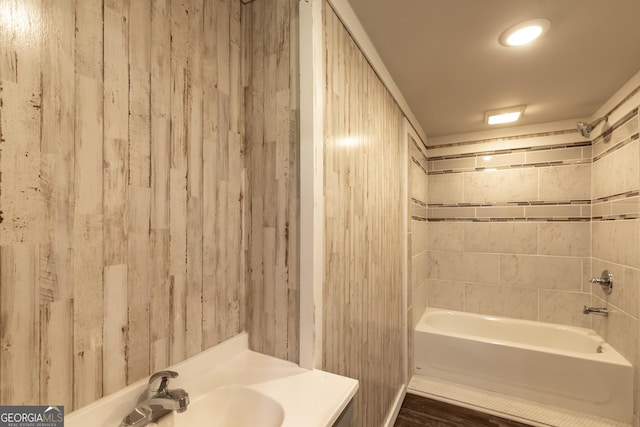 bathroom featuring wood finished floors, shower / washtub combination, and vanity