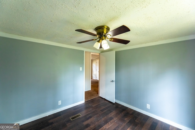 unfurnished room featuring visible vents, a ceiling fan, a textured ceiling, and dark wood-style flooring