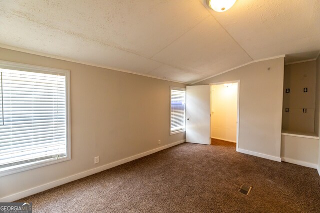 unfurnished room with a wealth of natural light, carpet flooring, vaulted ceiling, and baseboards