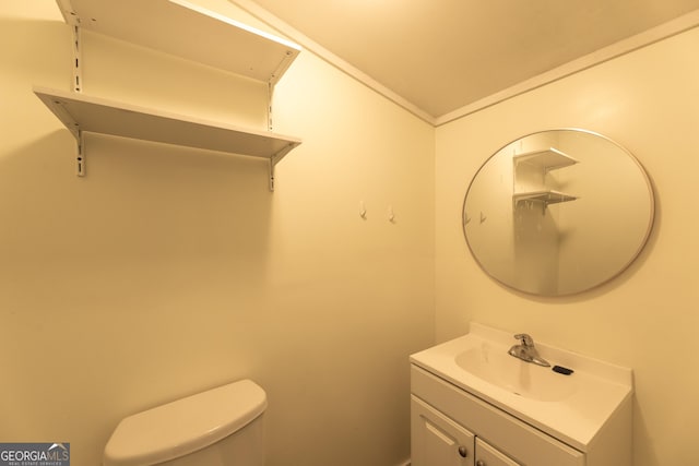 bathroom featuring toilet, vaulted ceiling, and vanity