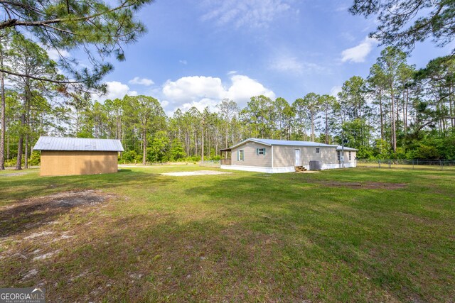 view of yard with central AC unit and fence
