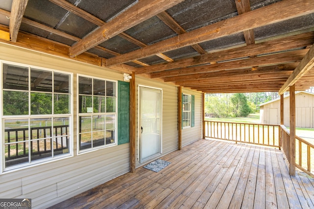 wooden terrace with an outdoor structure and a storage shed