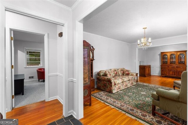 2558 Landeau Cir, Tucker, GA 30084 - living area with visible vents, wood finished floors, a notable chandelier, and crown molding