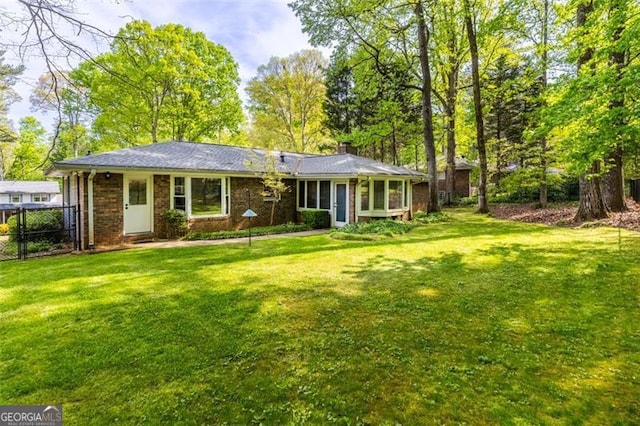 2558 Landeau Cir, Tucker, GA 30084 - back of house with a chimney, brick siding, fence, and a yard