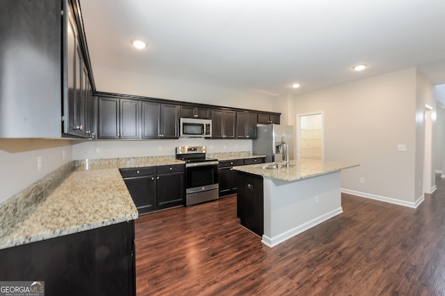 89 Citadel Dr, Hampton, GA 30228 - kitchen with recessed lighting, a center island with sink, light stone counters, appliances with stainless steel finishes, and dark wood finished floors