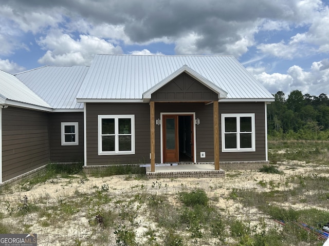 rear view of house with a porch and metal roof