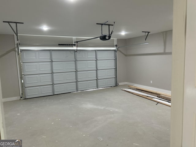 garage featuring a garage door opener and baseboards
