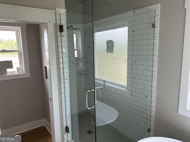full bathroom with a stall shower and baseboards