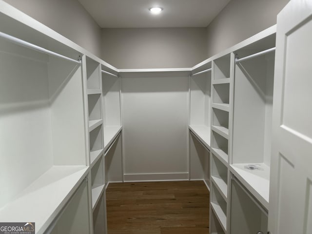 walk in closet with dark wood-type flooring