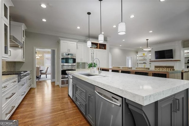 kitchen with gray cabinets, a large island, a sink, stainless steel appliances, and white cabinetry