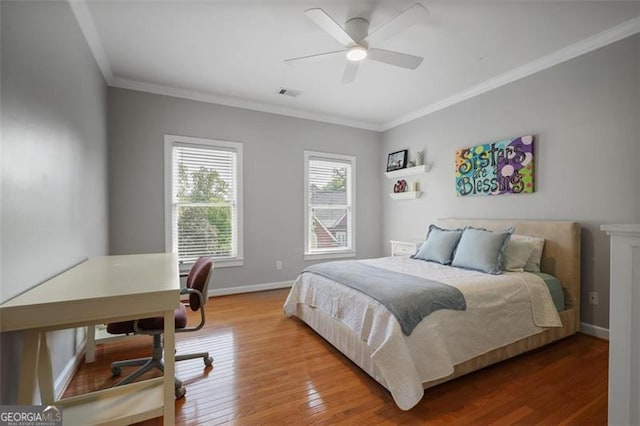 bedroom with visible vents, ornamental molding, baseboards, and wood finished floors