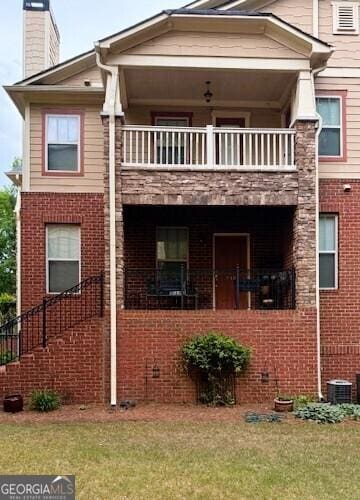 view of home's exterior featuring brick siding and a balcony