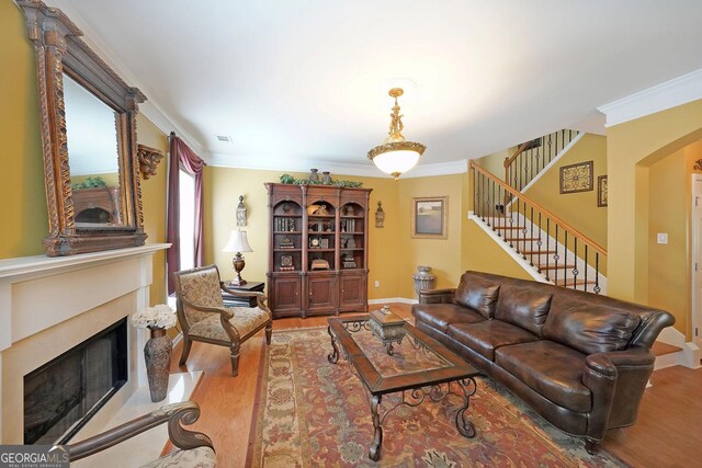 718 Province Pl SE, Atlanta, GA 30312 - living area featuring a fireplace, wood finished floors, ornamental molding, stairway, and arched walkways