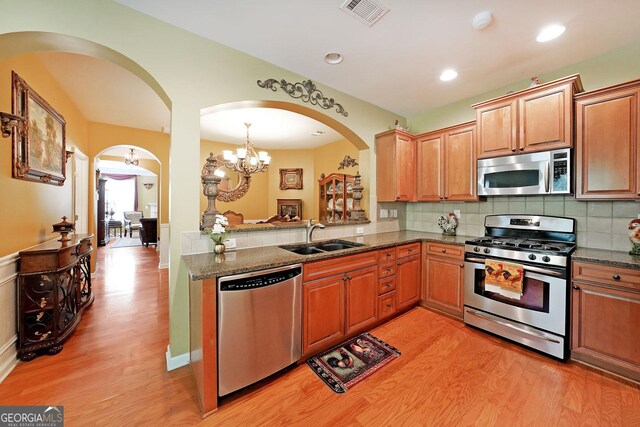 718 Province Pl SE, Atlanta, GA 30312 - kitchen with appliances with stainless steel finishes, a sink, light wood finished floors, arched walkways, and recessed lighting