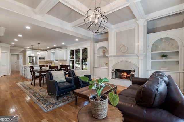 living room featuring ornamental molding, wood finished floors, recessed lighting, a premium fireplace, and coffered ceiling