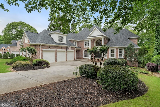 view of front of home with brick siding, concrete driveway, a garage, and roof with shingles