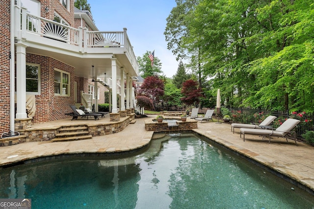 view of pool with a fire pit, a patio, and fence