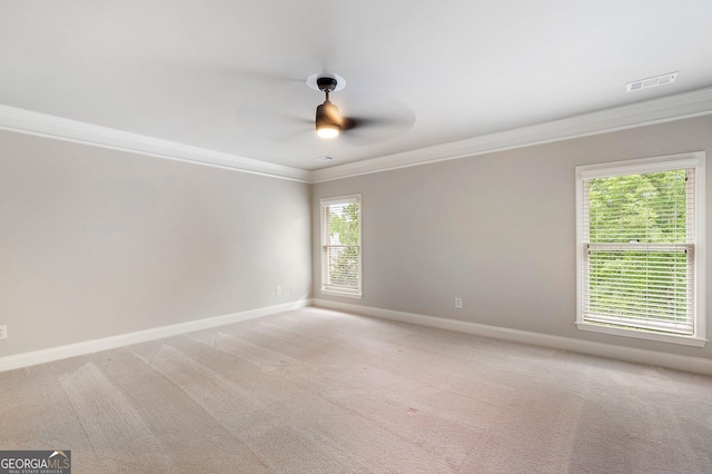 spare room with ornamental molding, baseboards, a ceiling fan, and light colored carpet