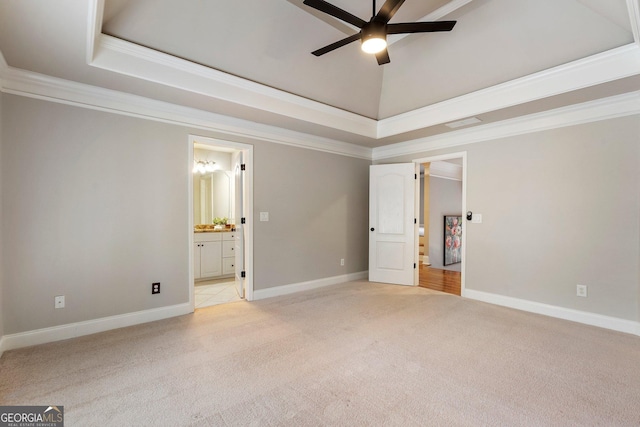 unfurnished bedroom with light colored carpet, crown molding, a raised ceiling, ensuite bathroom, and baseboards