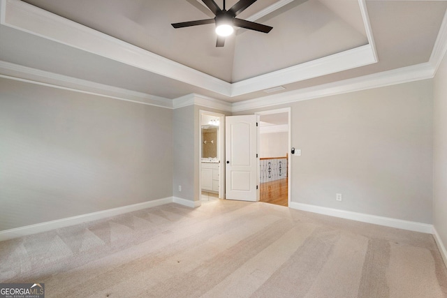 carpeted spare room with a ceiling fan, baseboards, crown molding, and a raised ceiling