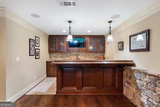 indoor wet bar with light wood-type flooring, backsplash, crown molding, pendant lighting, and recessed lighting