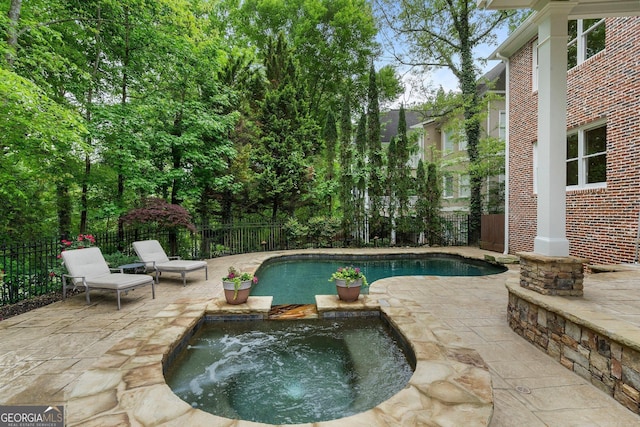 view of pool featuring a fenced backyard, a patio area, and a pool with connected hot tub