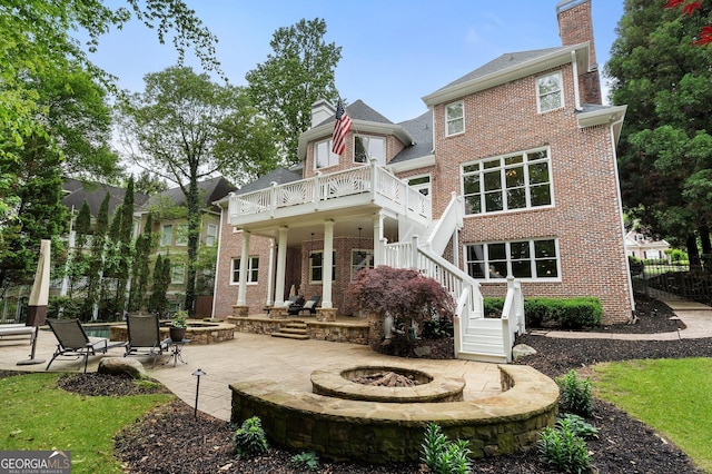 back of house with an outdoor fire pit, a chimney, a patio area, and brick siding