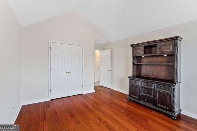 675 Michael Cir, Monroe, GA 30655 - unfurnished bedroom featuring wood finished floors, lofted ceiling, a closet, and baseboards