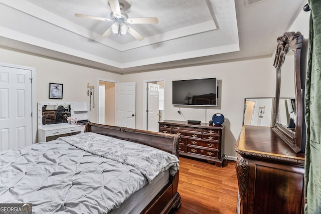 675 Michael Cir, Monroe, GA 30655 - bedroom with a raised ceiling, wood finished floors, a ceiling fan, and baseboards