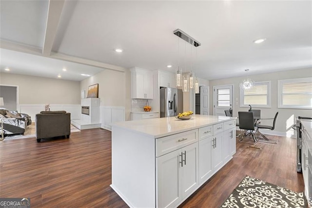 2490 Turtle Ter, Grayson, GA 30017 - kitchen with decorative light fixtures, stainless steel refrigerator with ice dispenser, white cabinetry, a kitchen island, and dark wood finished floors