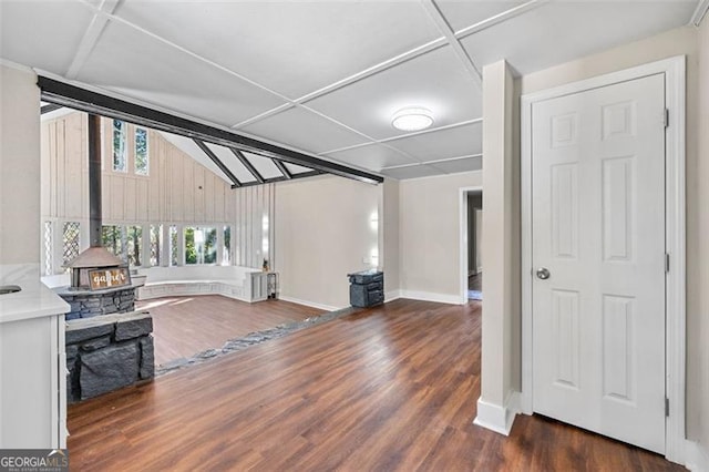 2490 Turtle Ter, Grayson, GA 30017 - unfurnished living room featuring beam ceiling, wood finished floors, a wood stove, and baseboards