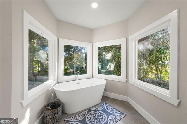 2490 Turtle Ter, Grayson, GA 30017 - bathroom featuring a soaking tub, baseboards, and tile patterned floors