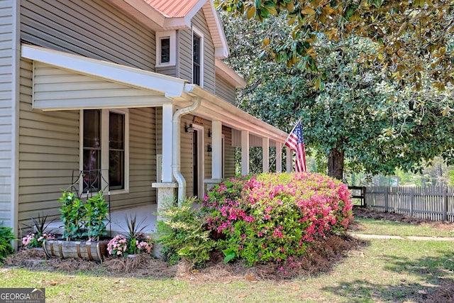 view of home's exterior with fence and covered porch