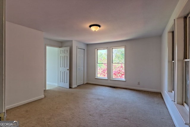spare room featuring baseboards and carpet